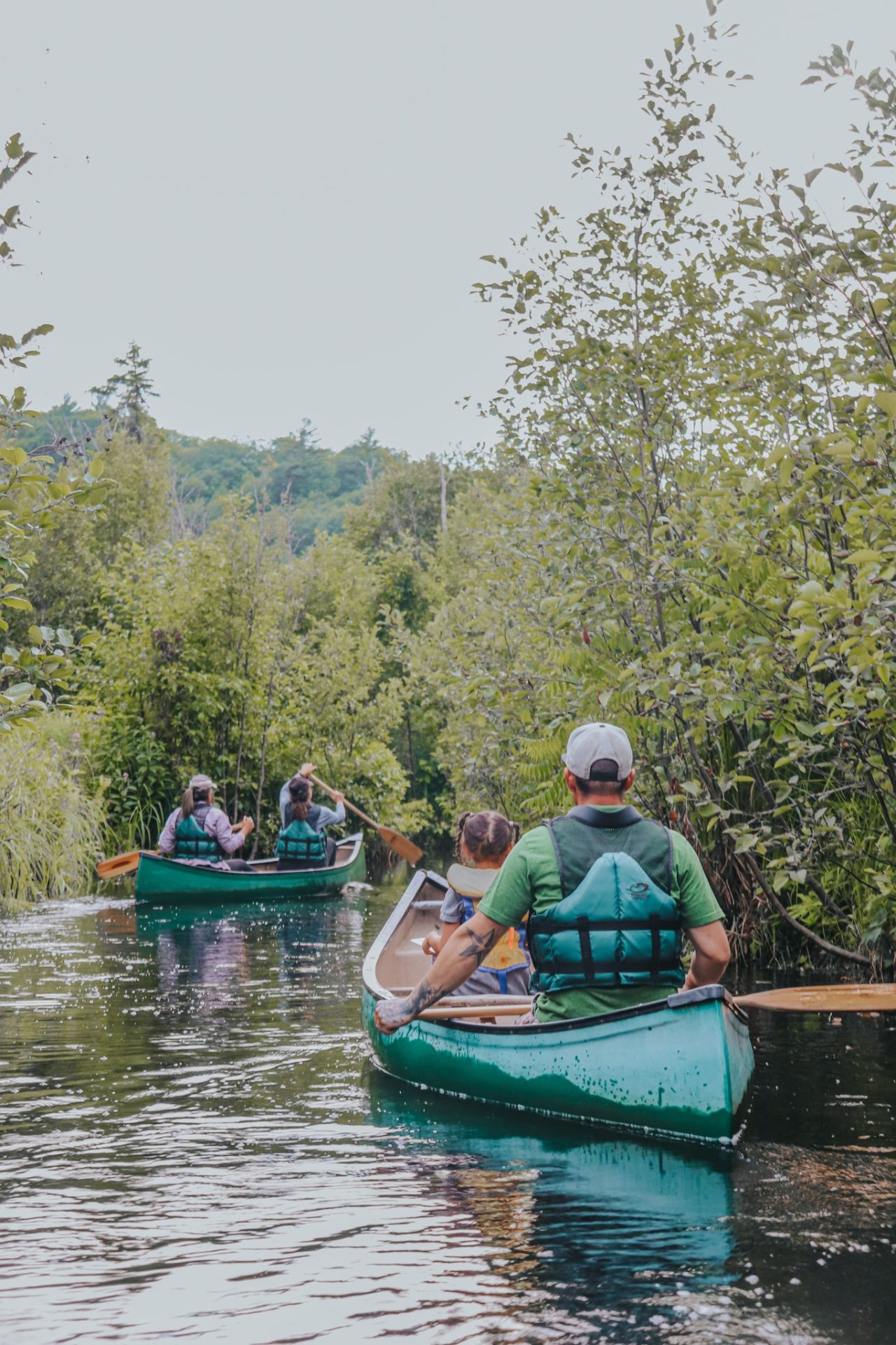 Des gens font du canoe sur une petite rivière